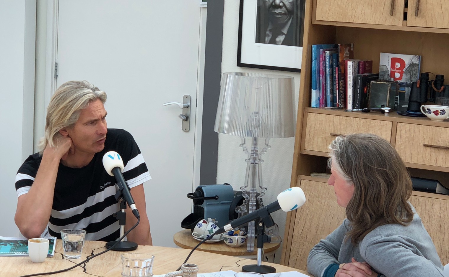 Ilco van der Linde aan de microfoon bij Petra Hoogerwerf, in het Nelson Mandelahuisje in Amsterdam-Noord.