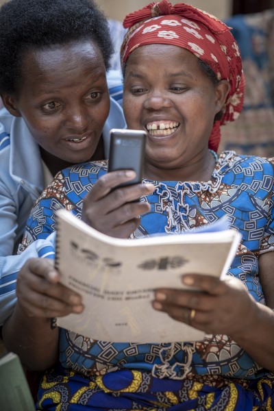 Vrouw in Rwanda met haar coach met een trainingsboek.jpg