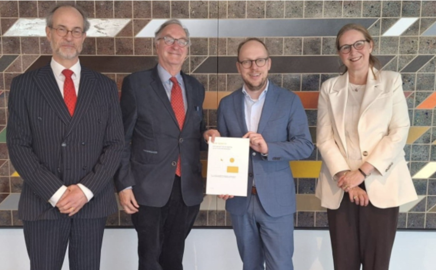 Eelco Eerenberg (blauw pak) krijgt Beter Geven III overhandigd, uit handen van J.L.W.M. Zuijdwijk (CIO-K), Alexander Rinnooy Kan (voorzitter commissie Beter Geven) en Margreet Plug (Goede Doelen Nederland) (vlnr).