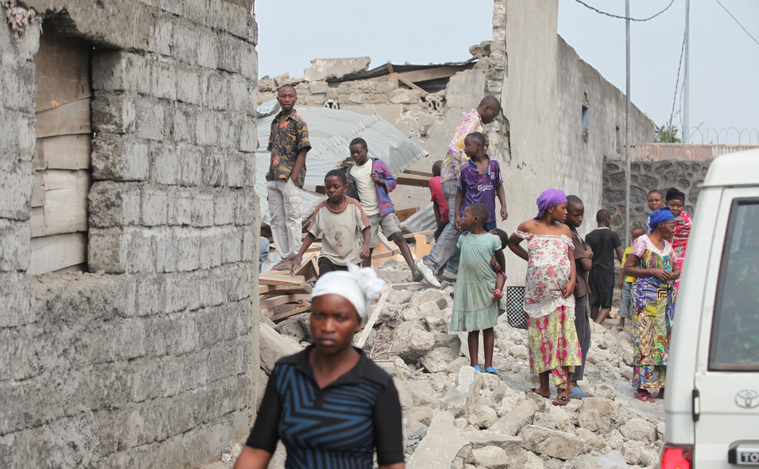 Bewoners van Goma kijken nieuwsgierig naar de restanten van een kerk die grotendeels verwoest werd na een granaatinslag.