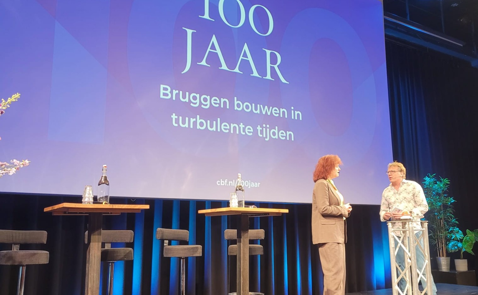 Harmienke Kloeze en Patrick Lodiers op het podium tijdens de viering van het honderdjarig bestaan van CBF.
