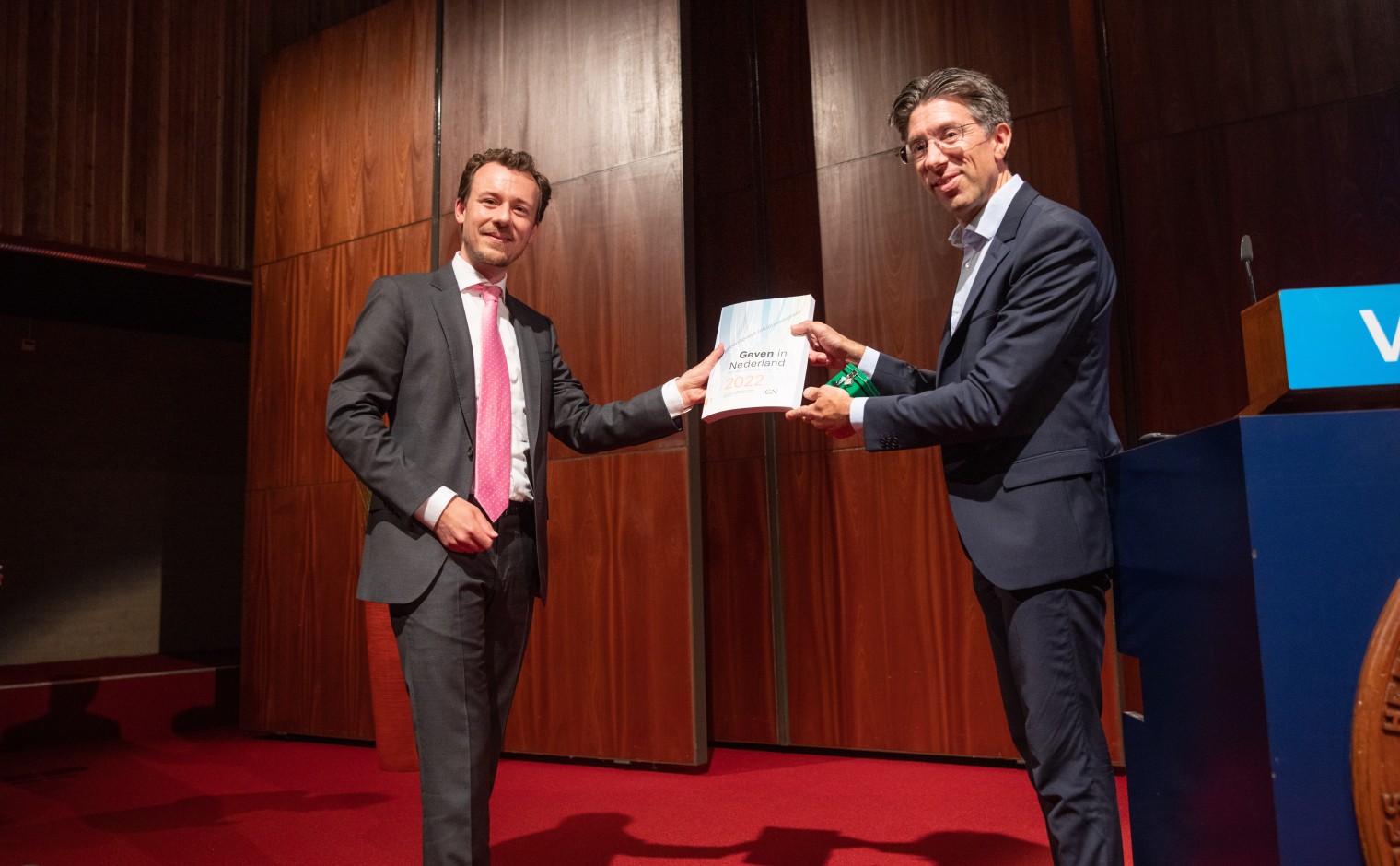 Rene Bekkers (r) overhandigt het eerste exemplaar van Geven in Nederland 2022 aan Fedor Meerts.