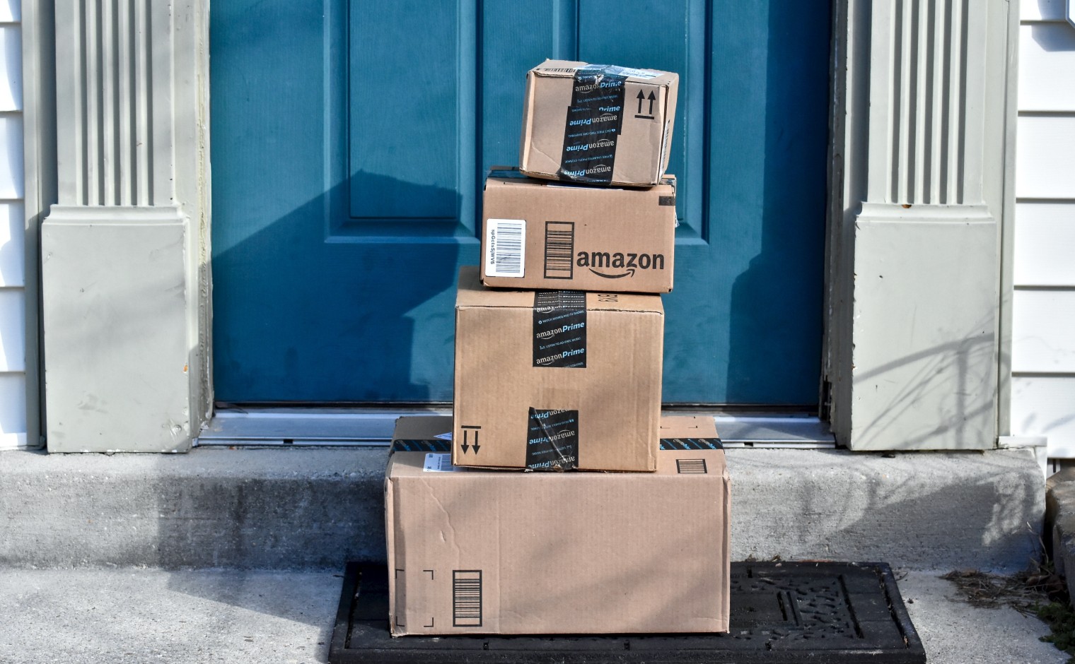 Een stapel dozen van Amazon op de drempel.