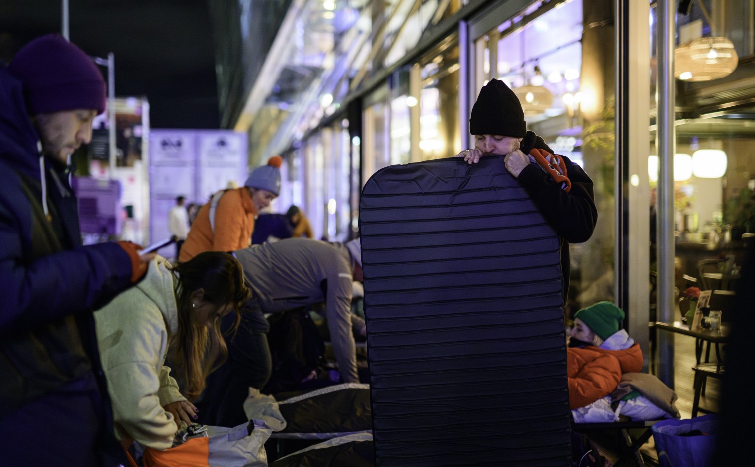 Een deelnemer aan de Sheltersuit Sleep Out blaast een matje op.