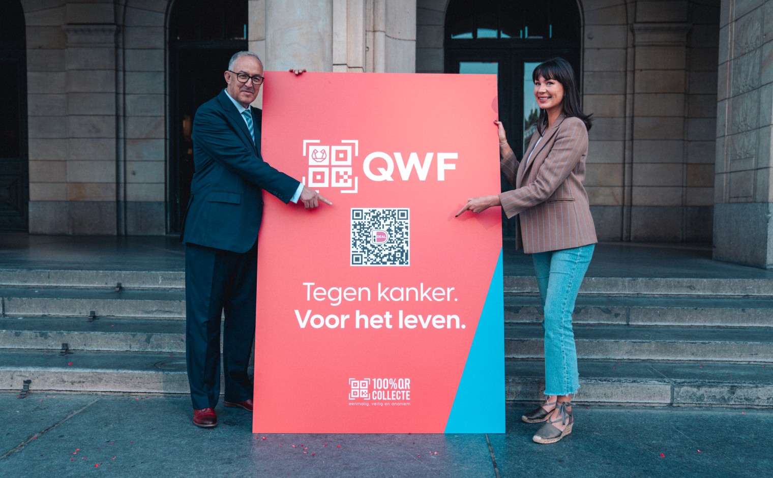 Burgemeester Ahmed Aboutaleb en Radio 2-dj Emmely de Wilt onthullen een QWF-collectebord voor het Stadhuis in Rotterdam.