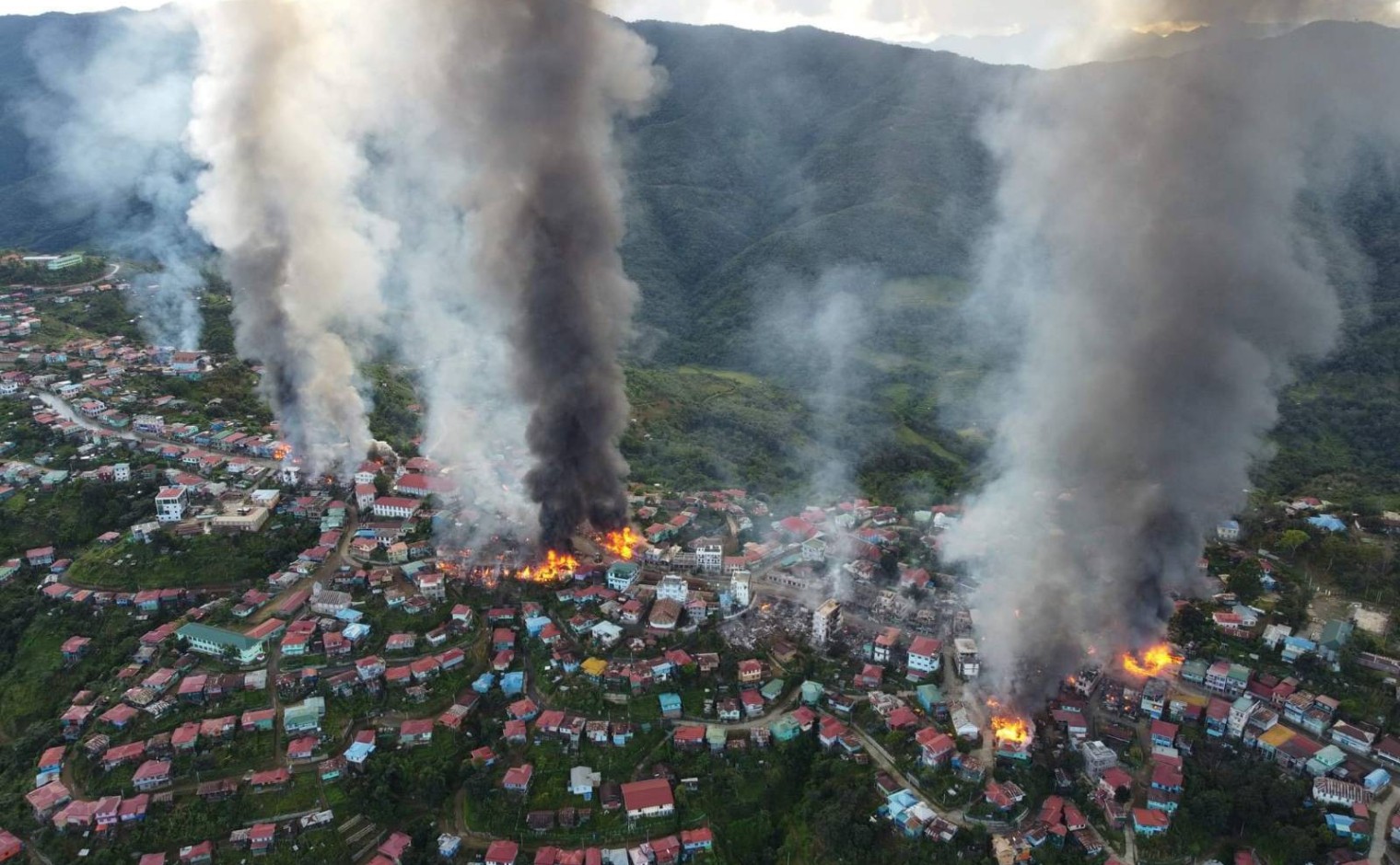Op verschillende plekken in Thantlang, Myanmar, staan gebouwen in brand.