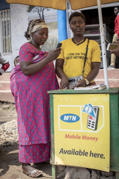 Vrouw in Rwanda haalt geld op bij mobile money kiosk.jpg