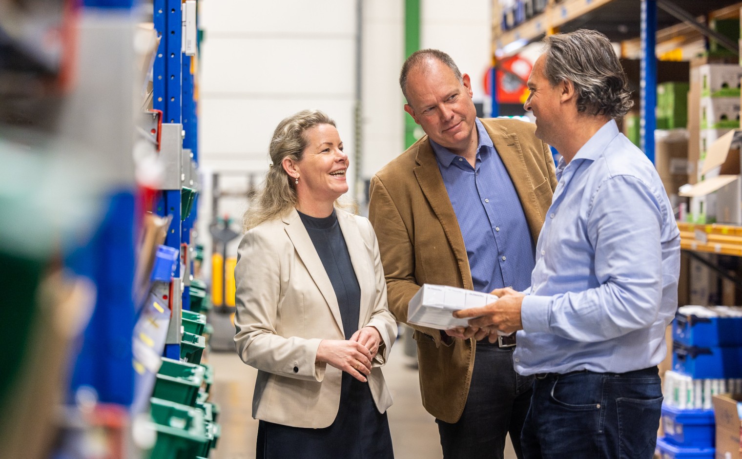Willemijn van Damme (zorghulp), Harco Eising en Paul Leuverink (Holland Pharma) in het logistieke centrum van Holland Pharma in Borculo.